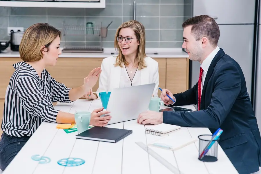 Colleagues meeting around a laptop in a bright office