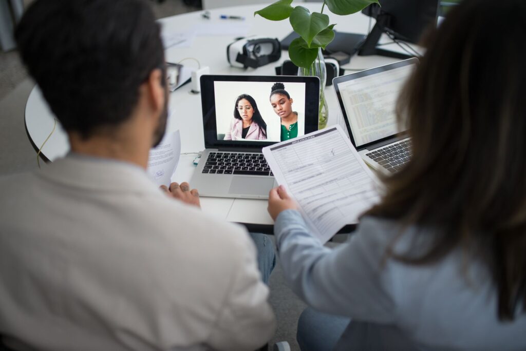 Advisors on a video call with clients while reviewing paperwork